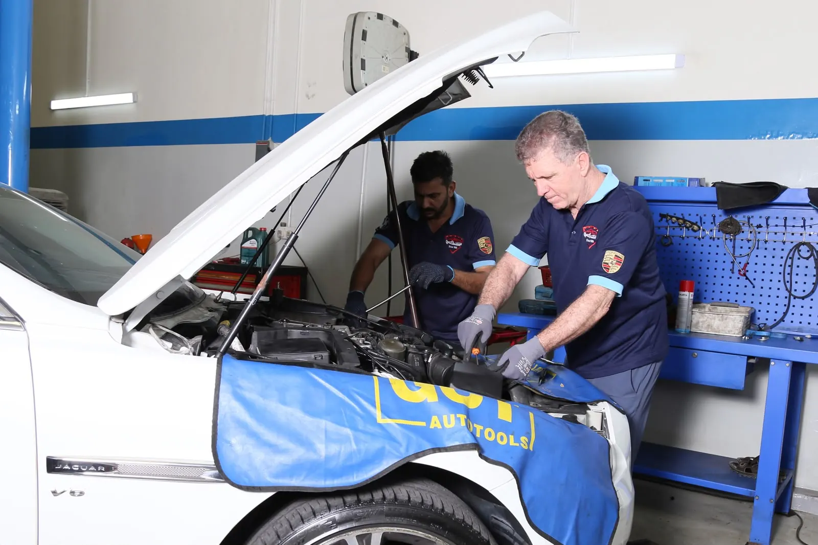 Technician inspecting suspension and under-chassis components in Abu Dhabi